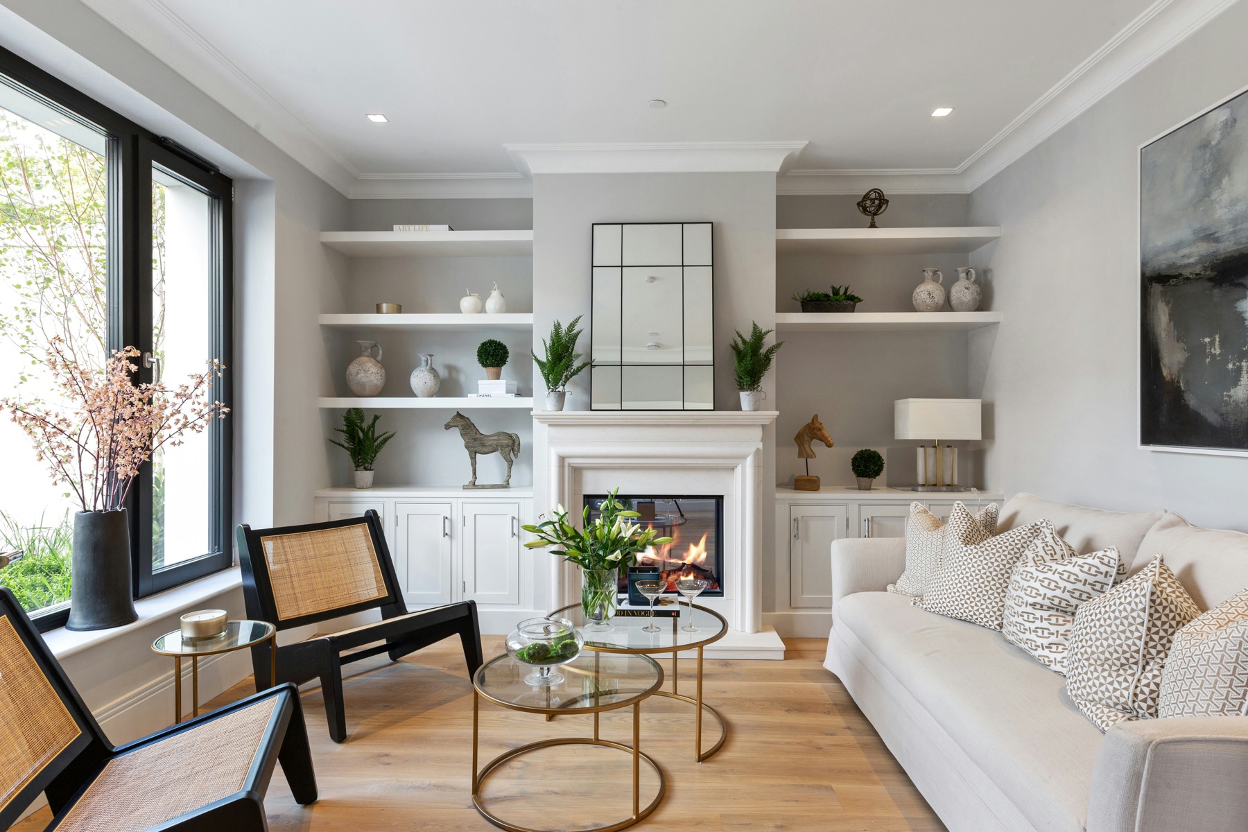 Staged living room with fireplace, built-in shelving, and neutral furnishings