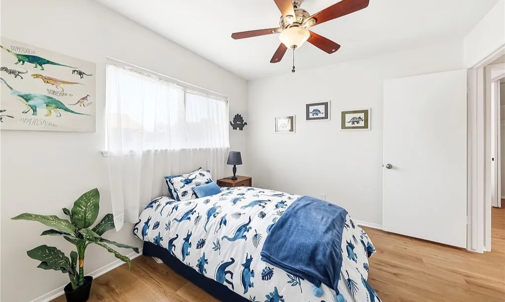 Staged kids' bedroom with dinosaur bedding and artwork